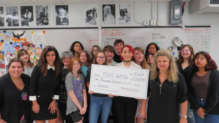Angela Zervos and Lauren Calta posing with a large check with teachers and students for Tarpon Springs High School Art Club Donation