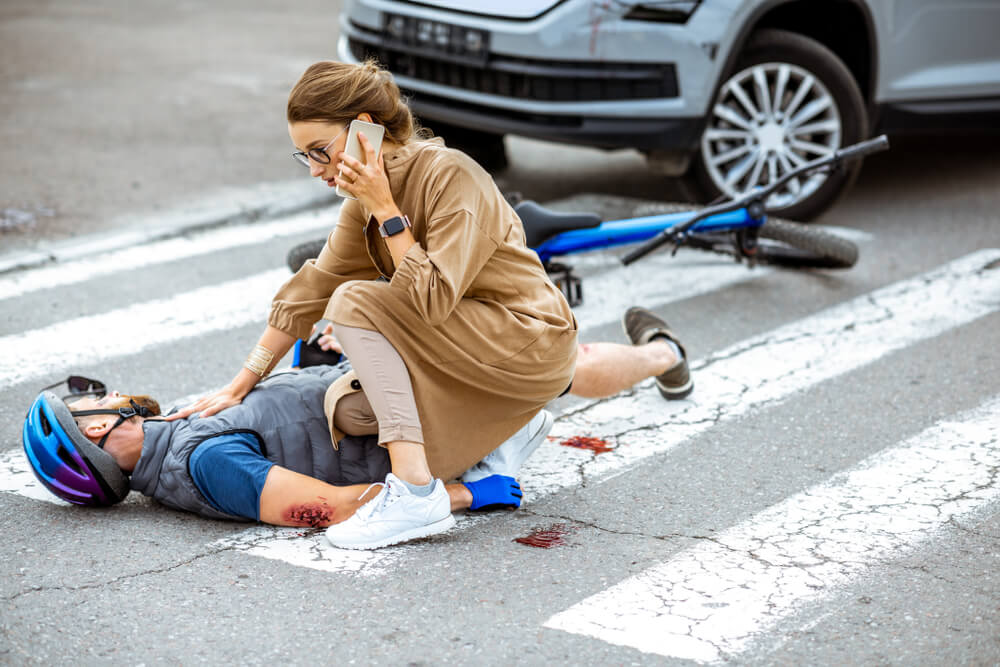 Woman driver calling 911 for injured pedestrian.