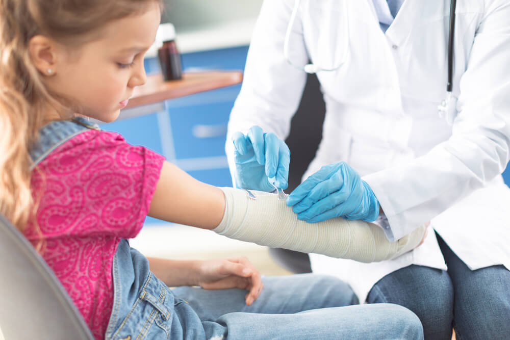 Doctor putting bandage on an injured child
