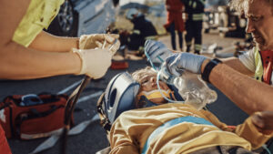 Paramedics rescuing injured victim from truck accident.