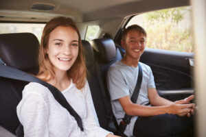 Passengers in back seat wearing seatbelts.