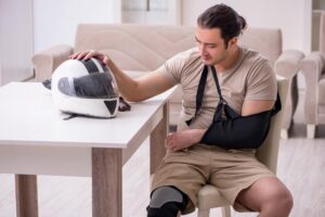 Injured motorcycle driver touching his helmet.