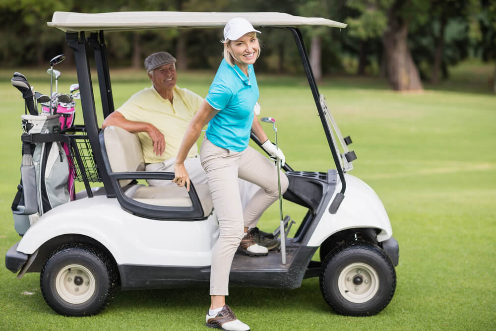Couple riding in a golf cart.