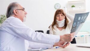 Young injured woman from car accident visiting her doctor.