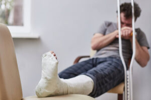 Injured man worried on his broken leg from accident.