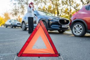 Lady driver calling insurance to report car accident.