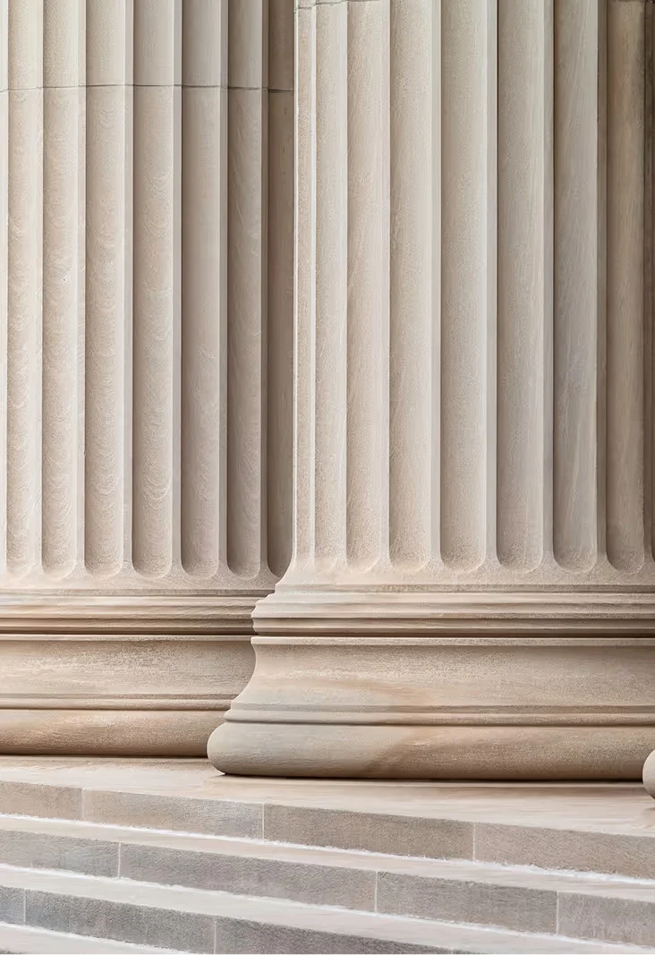 Close-up of fluted stone columns with stepped bases on a stone platform.